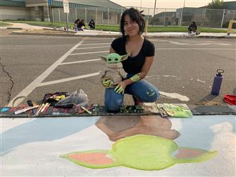 student painting sidewalk