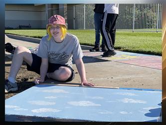 Senior student painting a sidewalk