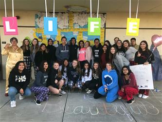 group of students standing in front of window display