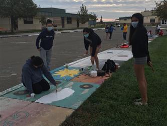 students painting the sidewalk