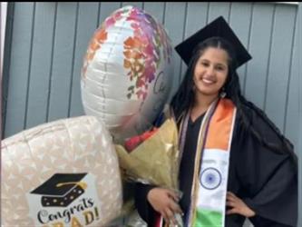 Graduate posing with balloons