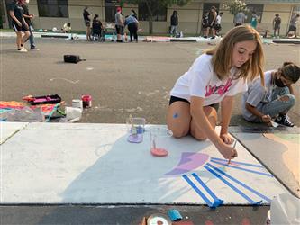 student painting sidewalk