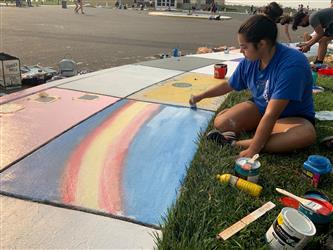 student painting sidewalk