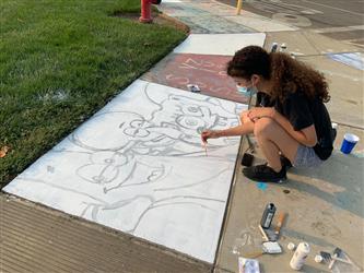 student painting sidewalk