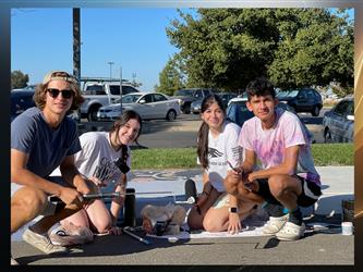 Senior students painting a sidewalk