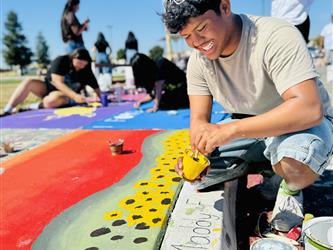 student painting on sidewalk