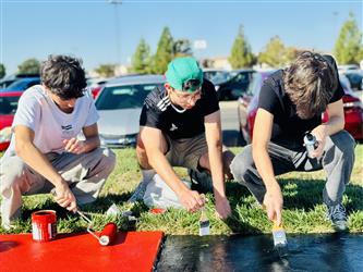 student painting on sidewalk