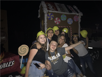 students in front of a parade float